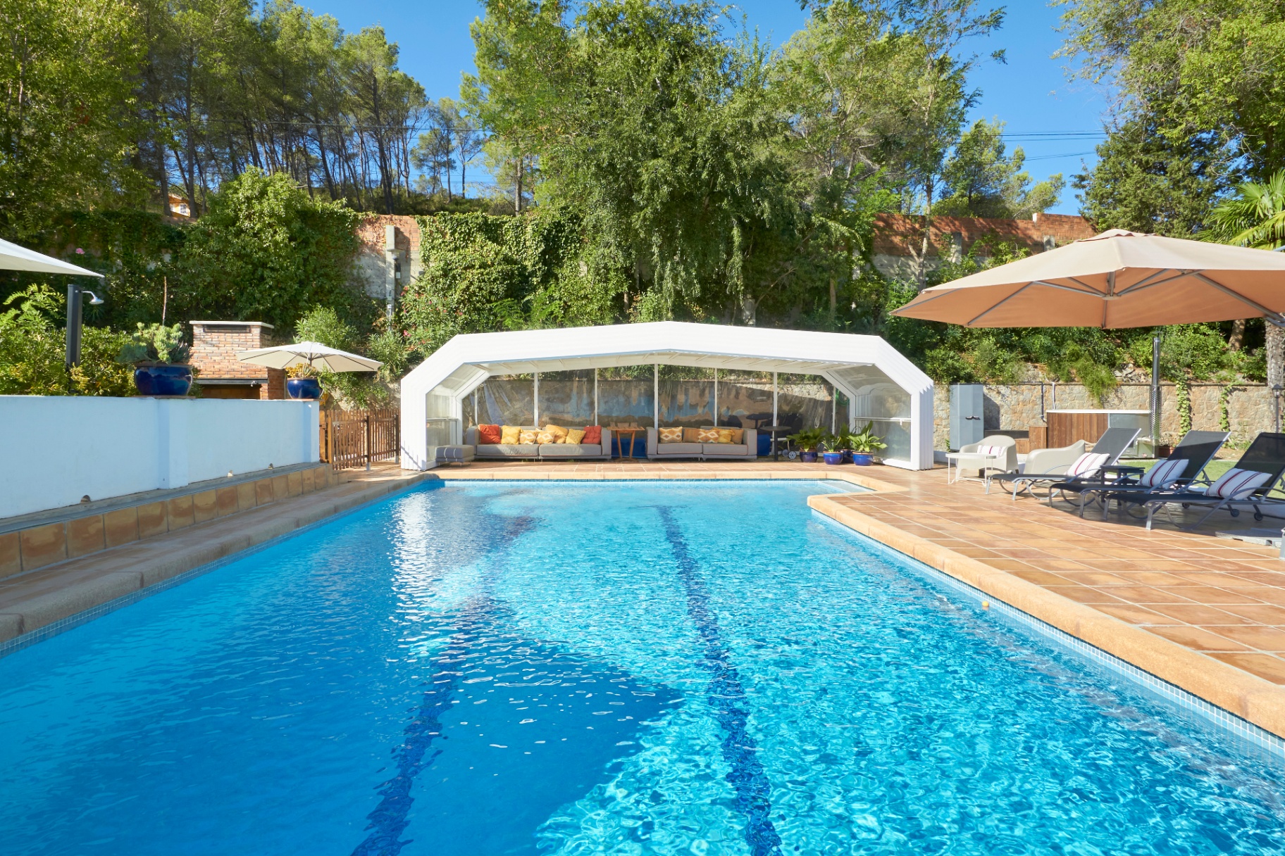 Piscine et abri rétractable dans le jardin de la Villa Marco